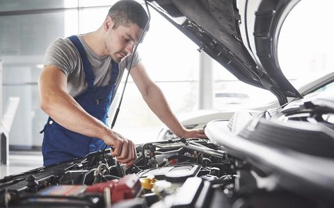 Mechanic inspecting a car in a repair workshop